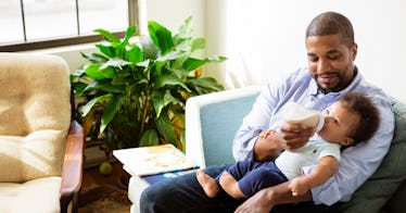 dad giving son a baby formula bottle