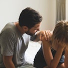 Man comforting upset wife on bed