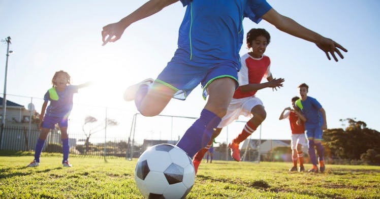 a kid kicks a soccer ball on a youth sports team