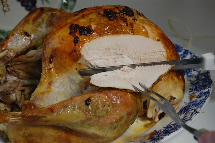 Roasted turkey being sliced from the side.