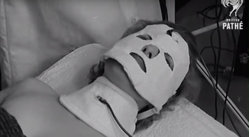 A person lying on their back with a white face mask in a modern spa