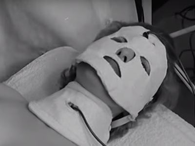 A person lying on their back with a white face mask in a modern spa