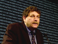 Eric Lander sitting during a press conference
