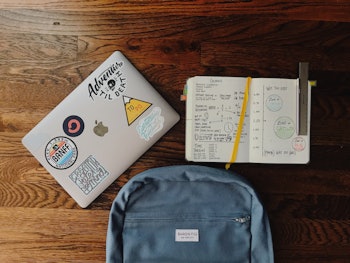 A school set of a backpack, laptop, and notebook