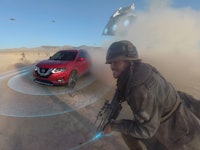 A red Nissan car driving to a dusty 'Star Wars' battle scene