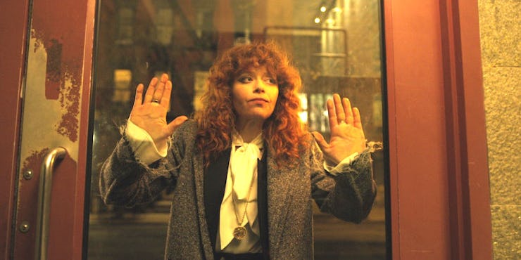 Natasha Lyonne in Russian Doll leaning against a glass door with her hands and face