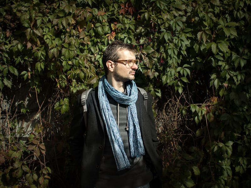 A man wearing one of the scarves that elevate any outfit and posing