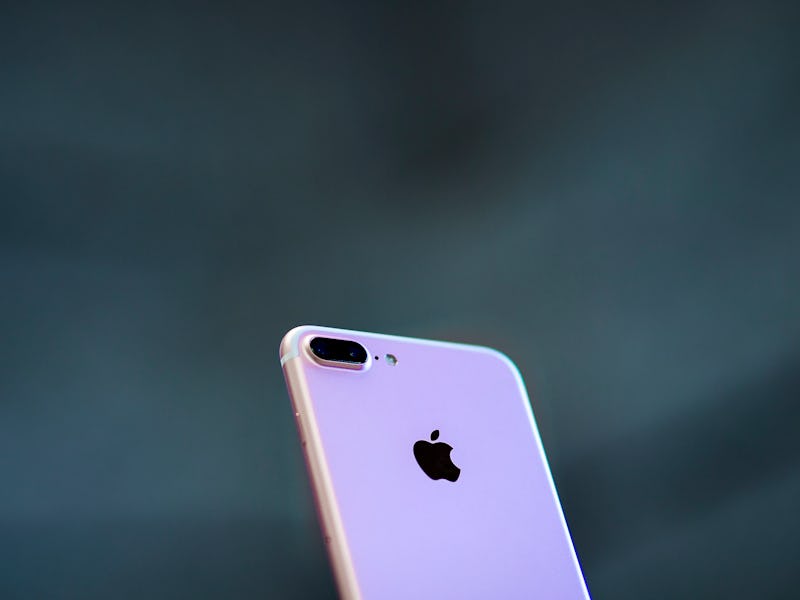 A slightly forward tilted white iPhone with a black backgound