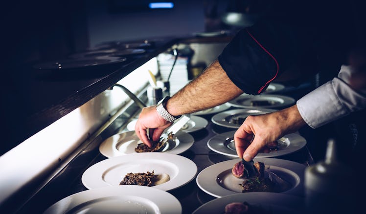 Cooks filling small plates with small portions of food