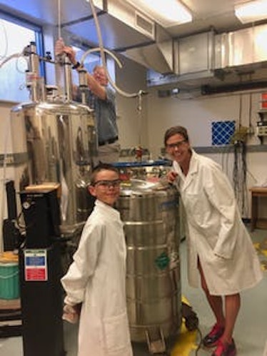 Dr. Karolien Denef and her son, Griffin, assist Dr. Christopher Rithner who is transferring liquid H...