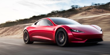 A red Tesla car on a road