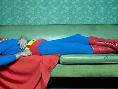 Christopher Reeve lying on a couch in a Superman costume