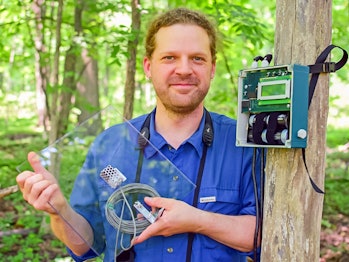 Prof. Dan Mennill with a flight call microphone and a digital recorder for recording migratory birds...