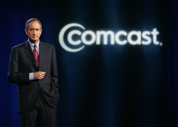 Brian L. Roberts posing next to a "Comcast" text sign
