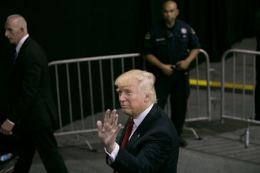 Donald Trump waving to people while walking