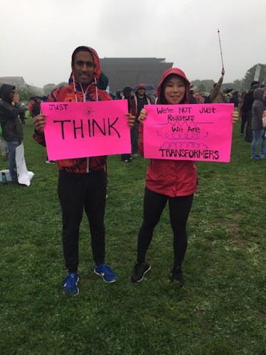 A man and a woman holding pink posters at the March for Science