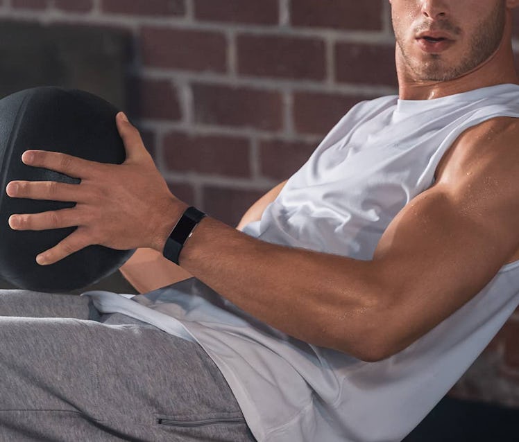 A man working out with a Fitbit fitness tracker on his hand