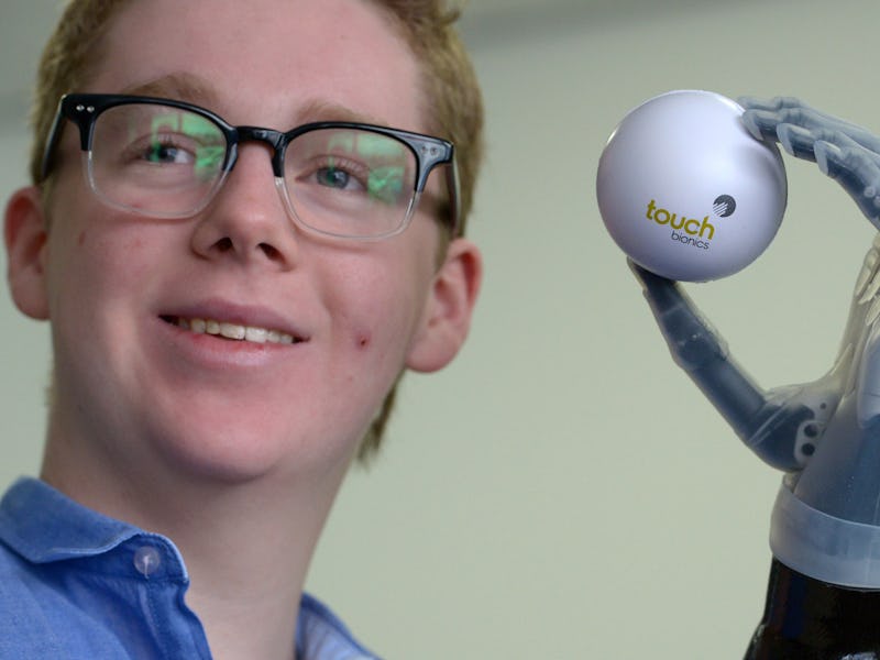 A man holding a ball with an electric hand