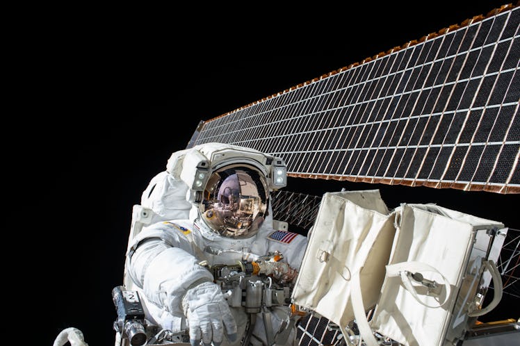 An astronaut working on the satellite in space