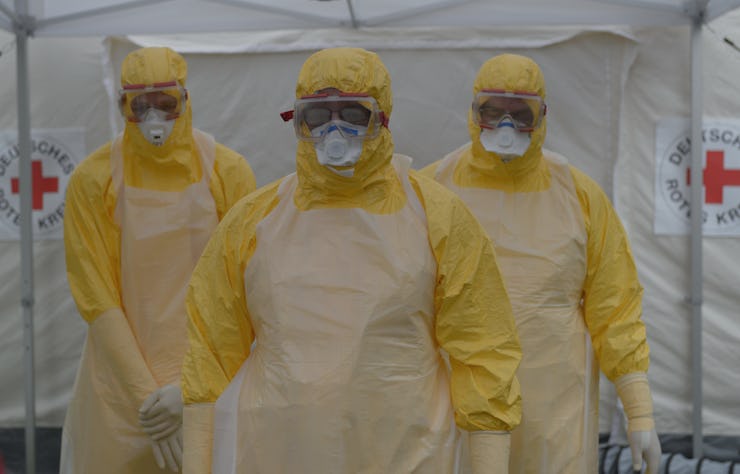 Three men wearing yellow protective suits and masks during pandemic