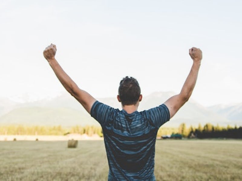 The back of a man with his arms high up, who is crushing it when it when it comes to budgeting