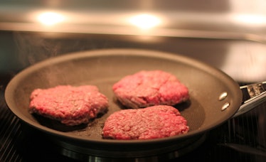 Burger meat getting fried on a pan