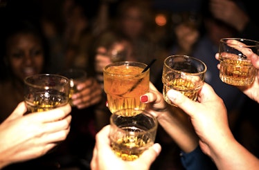 Group of friends toasting glasses of whiskey