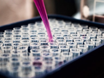An individual conducting scientific laboratory experiments using sample vials