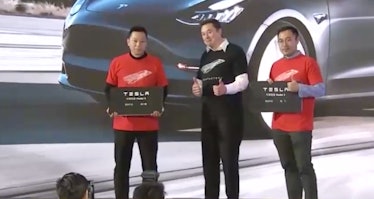 Musk hands over two giant key cards.