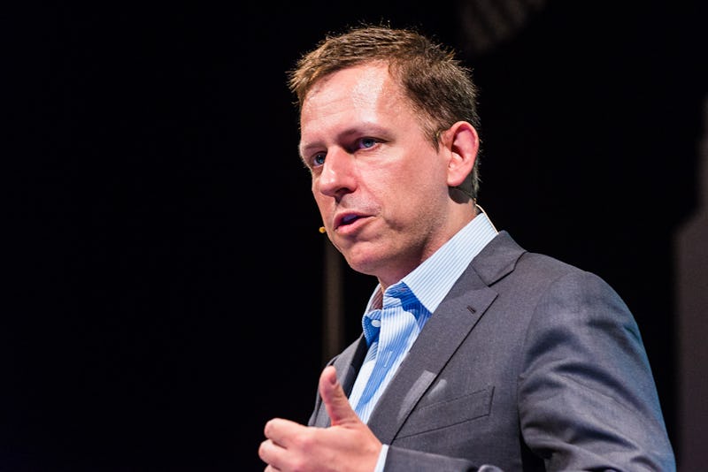 Peter Thiel in a grey suit and blue shirt giving a speech.