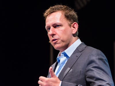 Peter Thiel in a grey suit and blue shirt giving a speech.