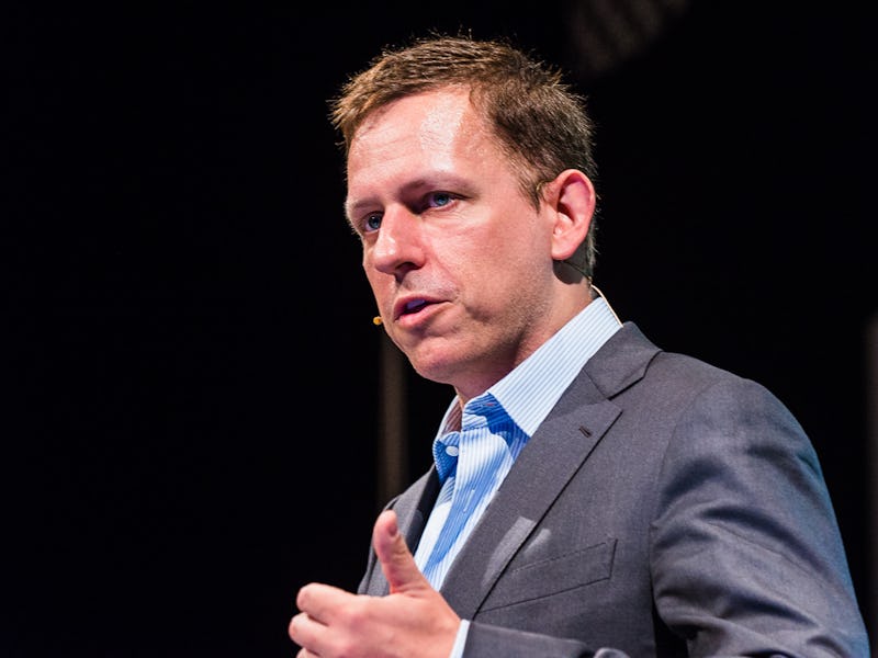Peter Thiel in a grey suit and blue shirt giving a speech.