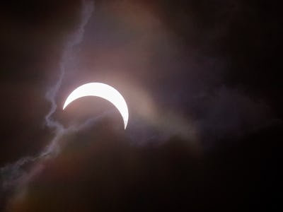 The moon shining bright among clouds on a night sky