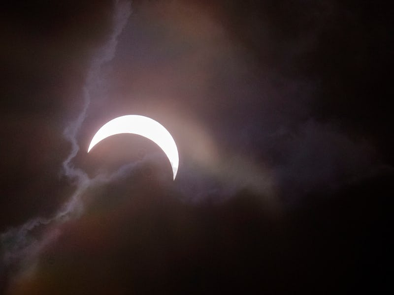 The moon shining bright among clouds on a night sky