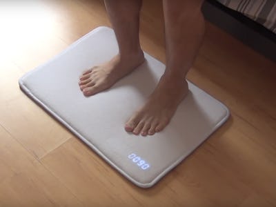 A person standing on a snooze-proof mat alarm clock