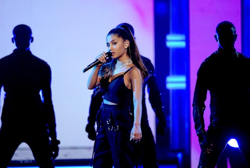 Ariana Grande performing on stage with her side profile visible