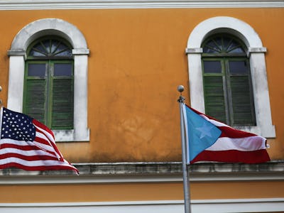 An orange building with the American and Puerto Rican flags hanged on it