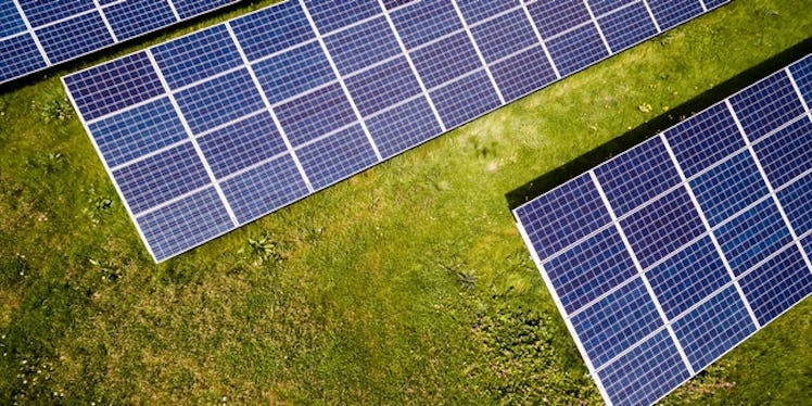 Three solar panels on a grass field