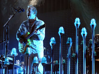 Bon Iver, also known as Justin Vernon, singing on a concert while playing his yellow guitar