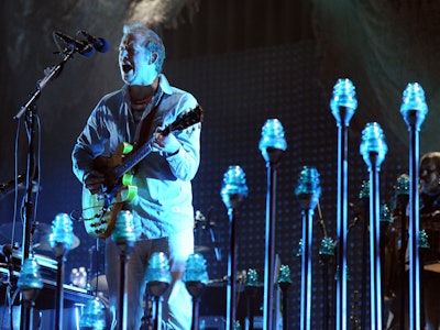 Bon Iver, also known as Justin Vernon, singing on a concert while playing his yellow guitar