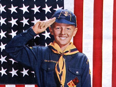 Boy Scout Merit Badges smiling in front of the United States flag
