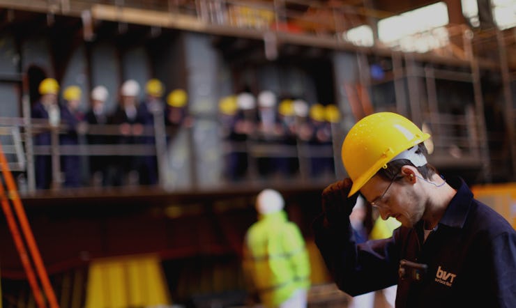 A construction worker removing his helmet