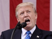 Donald Trump speaking in front of a microphone podium