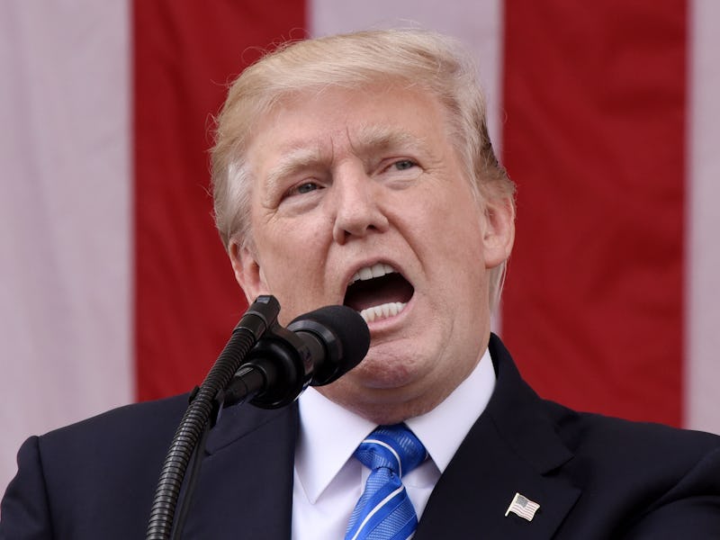 Donald Trump speaking in front of a microphone podium
