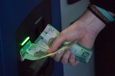 VANCOUVER, BC - OCTOBER 29: A user inserts Canadian currency into the world's first bitcoin ATM in e...
