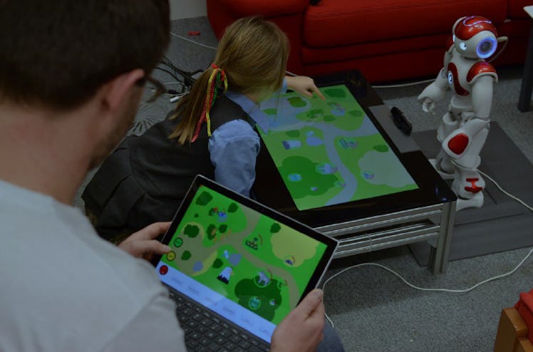 Child interacting with the robotic teaching aid during a laboratory test before heading to the prima...