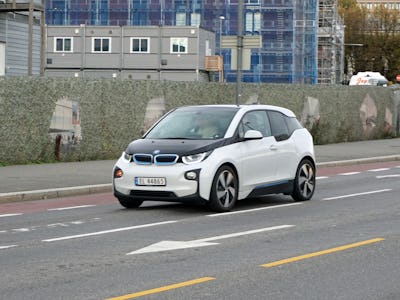 A black and white BMW car driving down a street in a city