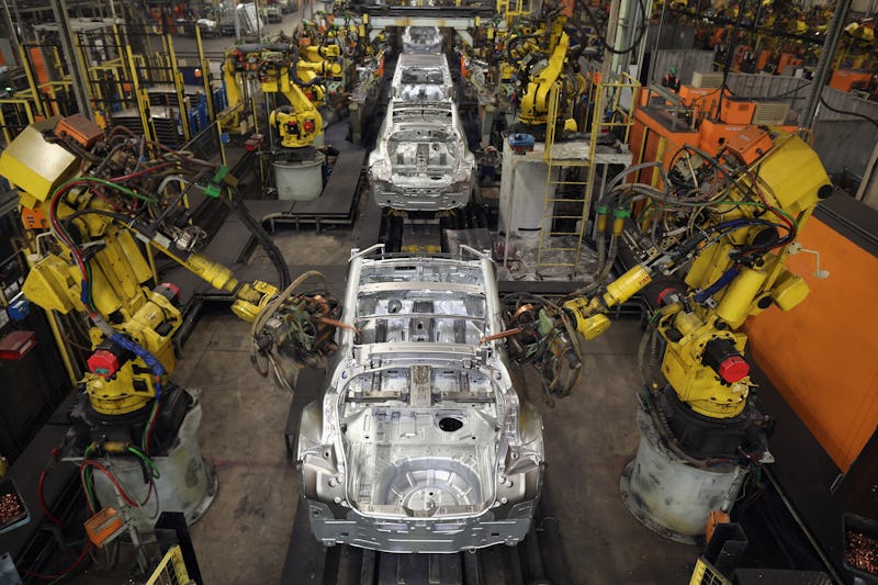A car factory with robotic elements putting segments together