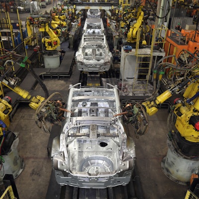 A car factory with robotic elements putting segments together