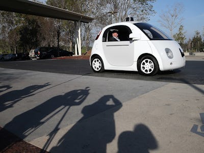A man sitting in a driverless white car 